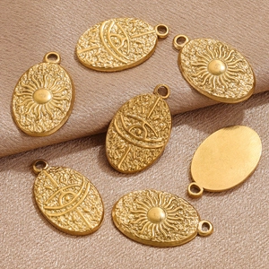 Gold stainless steel tarot sun and eye oval pendants on champagne satin background
