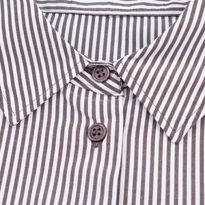 Macro detail of striped coffee and white shirt showing collar and premium brown buttons