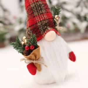 Christmas gnome plush with red plaid hat and pine branch in a snowy forest scene