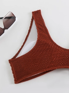 Detailed macro view of textured rust red bikini fabric with soft white inner lining