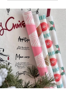 Papier de soie de Noël avec rayures roses et motifs de houx pour l'emballage de cadeaux festifs