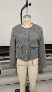 Détail de veste en tweed gris avec boutons dorés élégants et texture de tissu raffinée