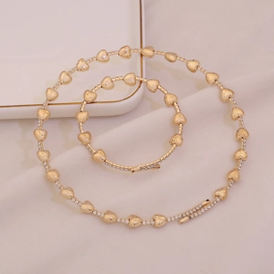 Elegante set di gioielli a cuore dorati con collana e braccialetto con diamanti incastonati