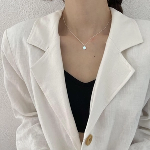 Minimalist 925 sterling silver necklace with light blue teardrop pendant on a model