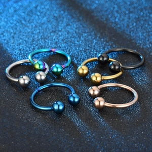 Set of six colorful horseshoe rings in stainless steel on blue glitter background