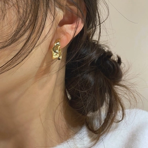 Chic irregular gold molten earrings in minimalist liquid metal style worn by a model