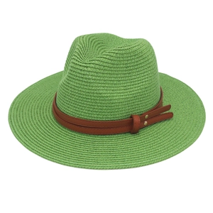 Detailed close-up of light green straw fedora with brown faux leather band and gold rivets