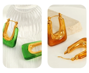 Detail of U-shaped geometric resin earrings in green and amber with gold metal trim