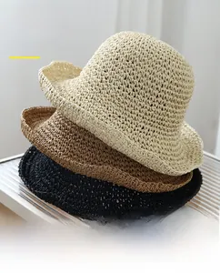 Detail of woven straw sun hats in beige and brown with UPF 50+ UV protection rating