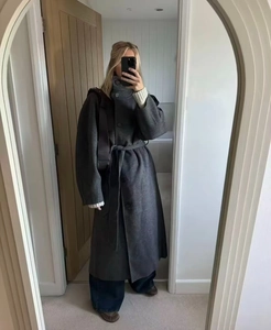 Dettaglio del cappotto lungo di lana grigio scuro con cintura e colletto a listino