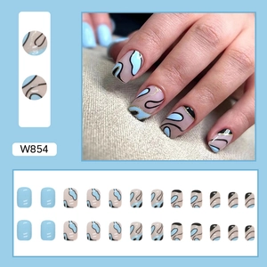 Short wavy blue and beige press-on nails with abstract black lines and gold glitter