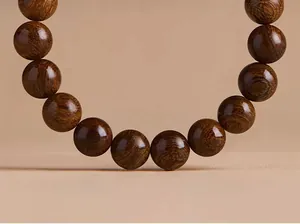 Macro detail of golden silk nanmu wood beads showing polished texture and natural grain