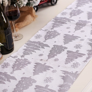 Christmas table runner featuring silver snowflakes and trees on white knitted fabric