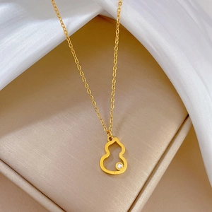 Macro shot of gold stainless steel necklace with hollow gourd pendant and crystal