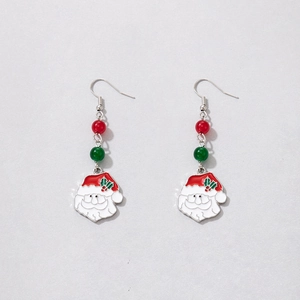 Close-up of Christmas earrings with red and green pearls and Santa Claus charms