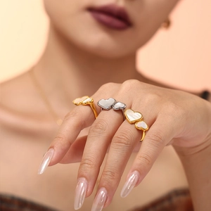 Minimalist stainless steel heart ring with natural shell inlay worn on a finger