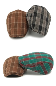 Detail view of plaid newsboy hats in various colors showing tweed texture and curved brims