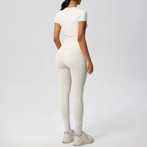 Detail of creamy white sports set featuring high-waist yoga pants and tight short sleeve tee