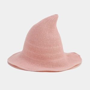 Detailed close-up of pink knitted witch hat showing fine crochet texture and wavy brim