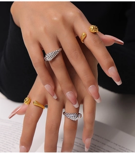 Detailed close-up of textured hammered finish open rings in gold and silver plating