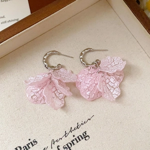 Detailed shot of pink crystal petal tassel earrings with silver hooks and iced texture