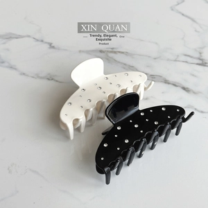 Macro view of black and white hair claws with sparkling rhinestones set on marble