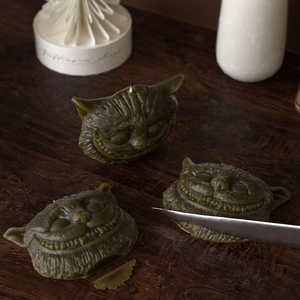 Three-piece set of Cheshire Cat scented candles with detailed carved facial features