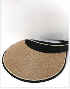 Detail of straw sun visor featuring large brim, black trim and metallic G logo accent