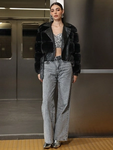 Women's faux fur jacket with leopard print top and grey wide-leg jeans in subway setting