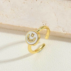 Vintage golden crescent moon and star ring with shell inlay on stone pedestal