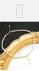 Vue détaillée d'un collier en perles d'eau douce avec un élégant pendentif fleur dorée
