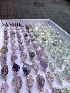 Bulk display of handmade wire wrapped rings with raw amethyst and fluorite stones