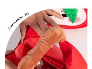 Detail view of red apple shaped gift bag with zipper opening showing internal space