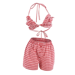 Detail of red and white plaid two-piece set featuring ruffle bikini top and high-waist shorts