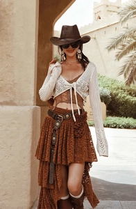 Bohemian western style outfit with studded leather belt and lace vest in desert setting