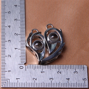 Detail view of heart-shaped magnetic pendants with size measurements on a scale ruler