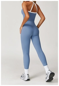 Detail van een yoga bodysuit in mistig blauw met gekruiste witte bandjes voor fitness