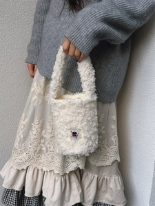 Detail of white fleece drawstring water bottle carrier bag with cute cartoon patch
