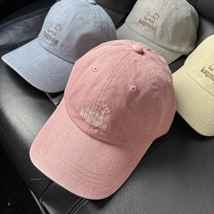 Close-up of four washed cotton baseball caps with cute dog and keynote embroidery