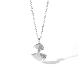 Close-up of a silver ginkgo leaf pendant necklace featuring radiant textured metal