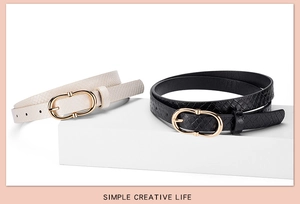 Detail of black and beige snake pattern slim belts with golden oval buckles on display