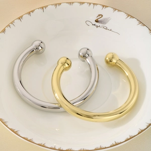 Minimalist C-shaped open bangles in gold and silver finish with sphere ends