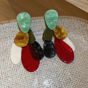 Macro detail of French vintage acrylic drop earrings with layered five-color stone texture