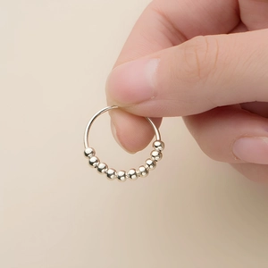 Close-up detail showing a stainless steel anxiety ring with ten rotatable beads