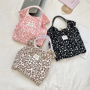 Detailed overhead view of floral tote bags featuring thick twisted rope handles in three colors