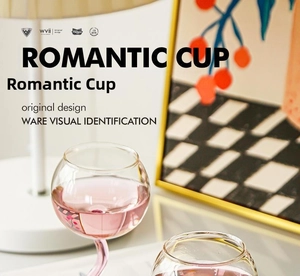 Detail shot of heart-shaped glass base with pink liquid and romantic high stem design