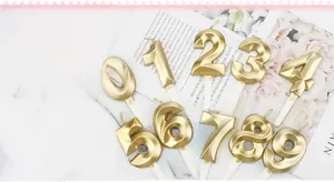 Close-up of golden diamond-shaped 0-9 number candles for birthday cake decoration