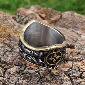 Vintage stainless steel ring with turquoise star and feather design on a rustic bark