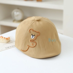 Detailed view of beige cotton beret with bear embroidery and diagonal twill texture