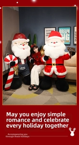 Detailed close-up of large plush Santa Claus dolls with festive outfits and Merry Christmas signs